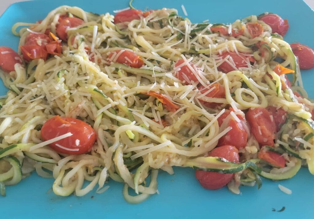 garlic parmesan zucchini spread out on a rectangular blue plate