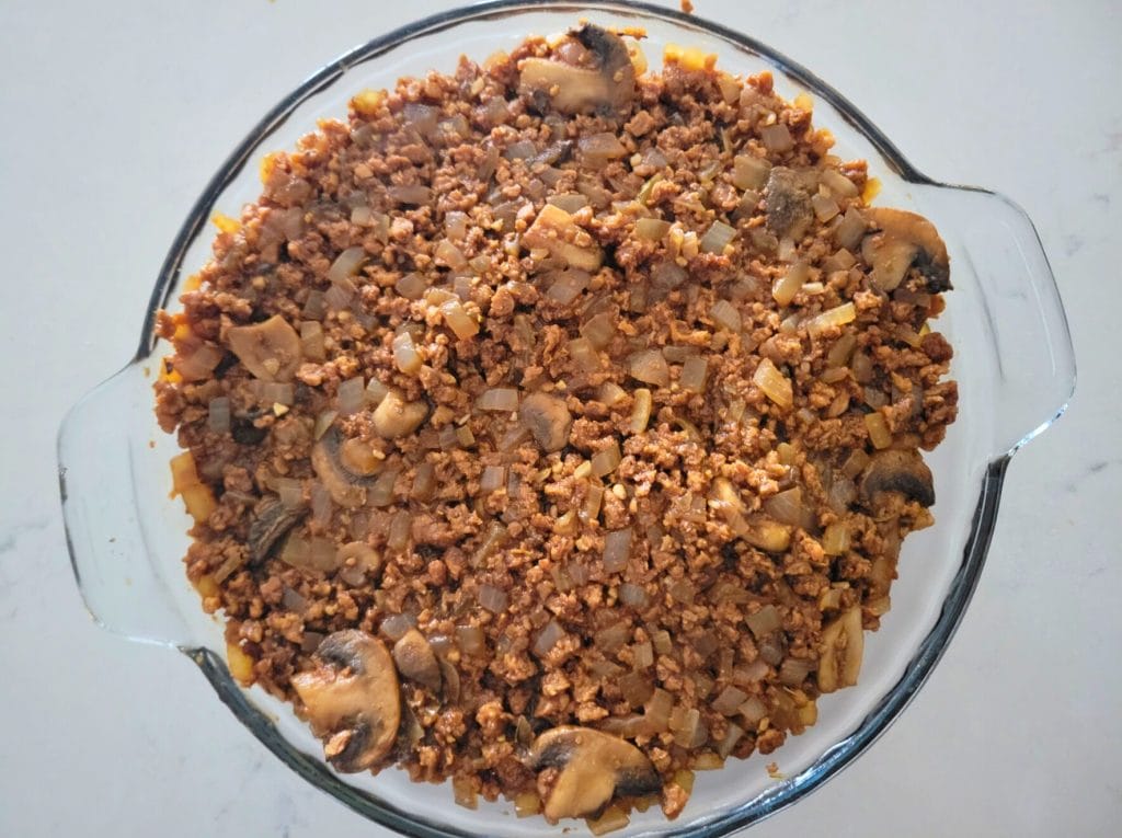Guinness Shepherd's Pie gravy filling in a glass pie dish 