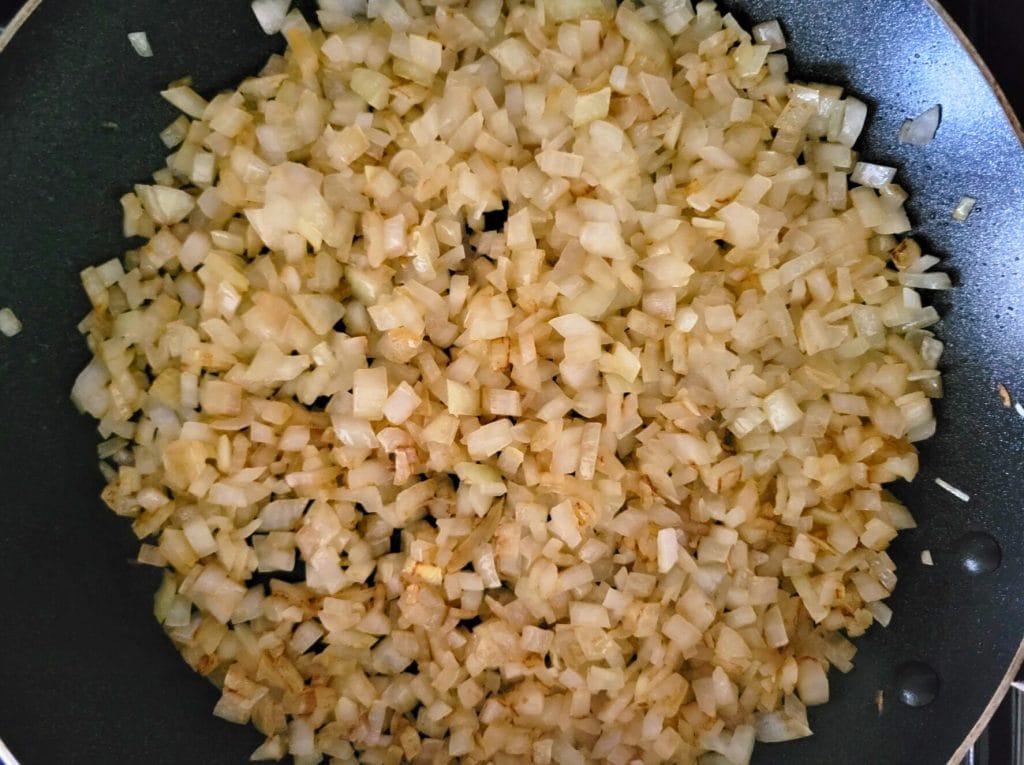 sauteed, diced onions in a black skillet