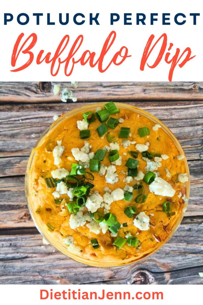 jackfruit buffalo dip in a clear bowl, sprinkled with sliced green onions and blue cheese, on a wooden surface. text above reads, "Potluck Perfect Buffalo Dip"