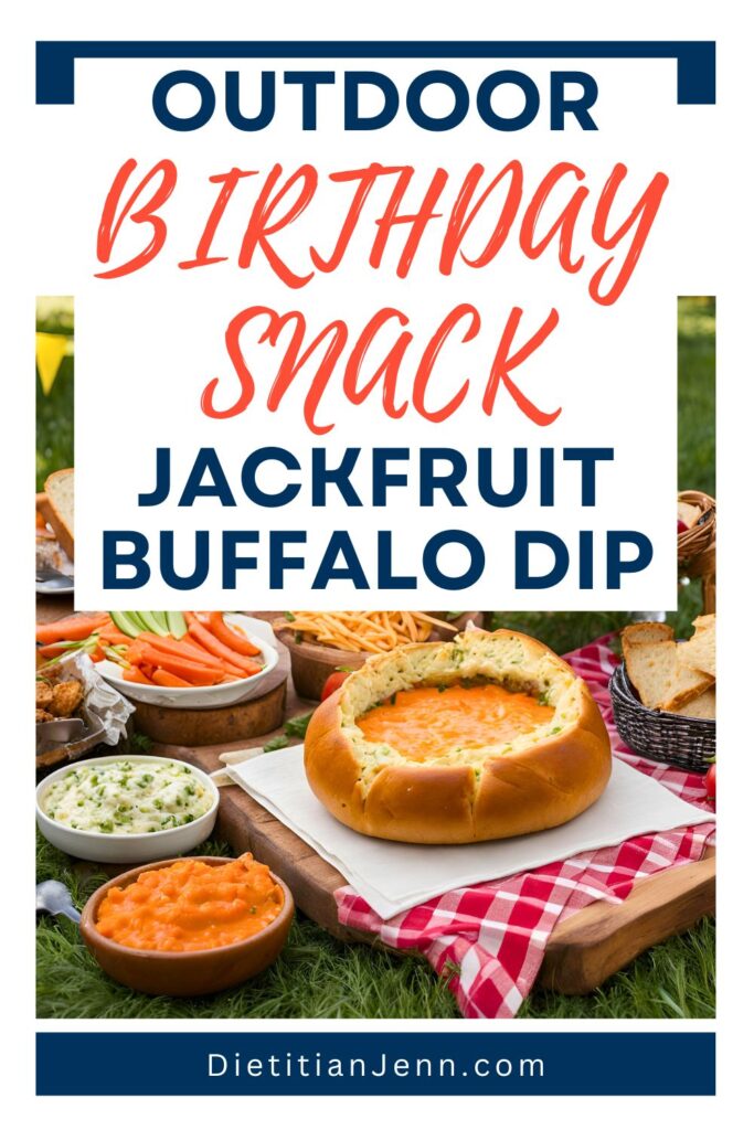 jackfruit buffalo dip served in a hollowed-out bread bowl, surrounded by bread chunks, veggies, and other dips set on a picnic blanket. Overlaid text reads, "Outdoor Birthday Snack: Buffalo Dip!"