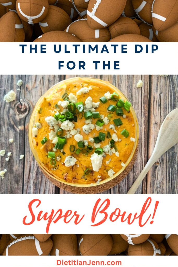 a background covered in American footballs. Overlaid is jackfruit buffalo dip in a clear bowl, sprinkled with sliced green onions and blue cheese, on a wooden surface. Text above and below reads, "The Ultimate Dip For The Super Bowl!