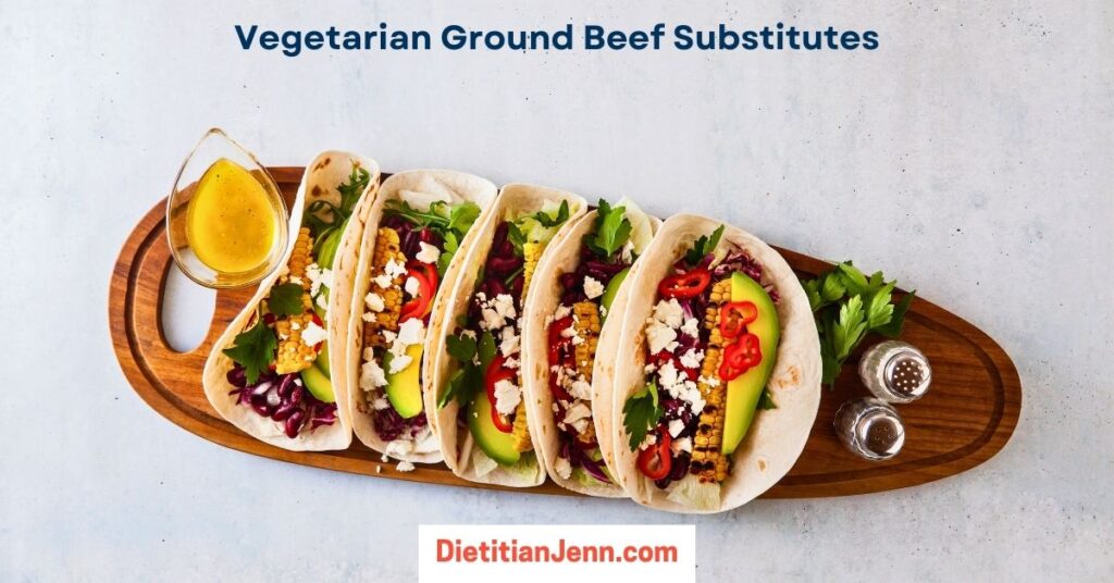 a long, oval wooden tray with 5 vegetable and black bean tacos on a grey concrete surface. Text above reads, "Vegetarian Ground Beef Substitutes"