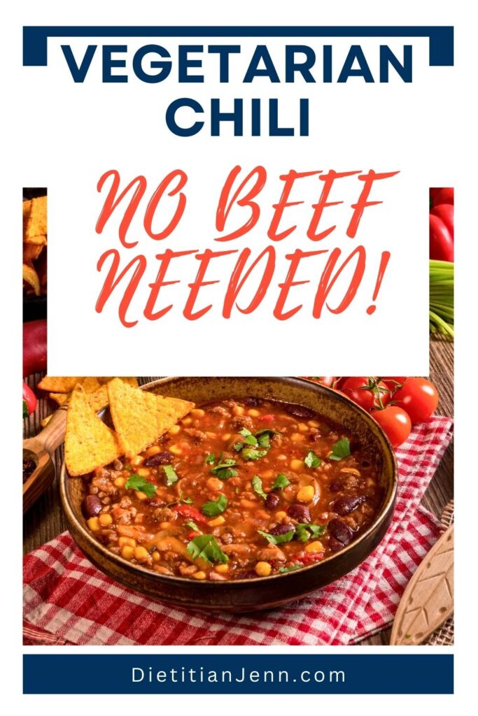 a brown bowl of lentil and black bean stew on a red checked tea towel, a variety of fresh veggies are in the background. Text above reads, "Vegetarian Chili, No Beef Needed"