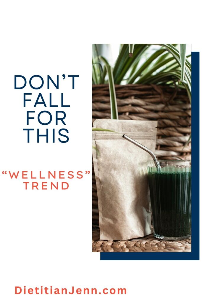 green juice in a clear glass next to an unlabeled supplement bag. text reads, "don't fall for this 'wellness' trend"